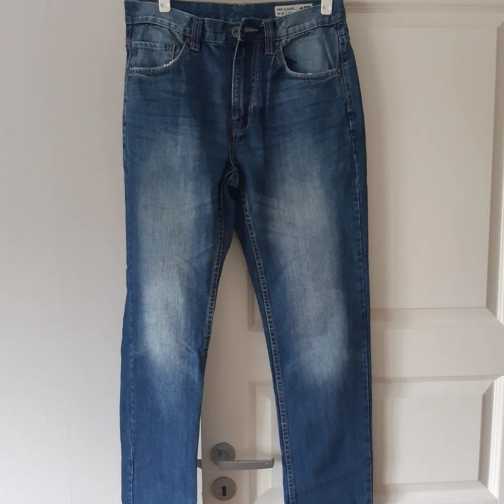 Säljer ett par klassiska blå jeans från märket 157. De har en snygg tvätt med lite ljusare partier fram och bak. Jeansen har en normal passform och är perfekta för vardagsbruk. De är i bra skick och redo för en ny ägare!. Jeans & Byxor.