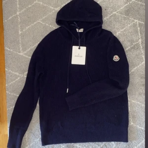 Moncler stickad tröja - Säljer nu denna stickade moncler hoodien i nyskick✅ Inga tecken på användning, den är i oerhört bra skick och i ett skönt material🧶 Hör av er vid frågor eller önskade bilder! 💥 Mvh John🍾