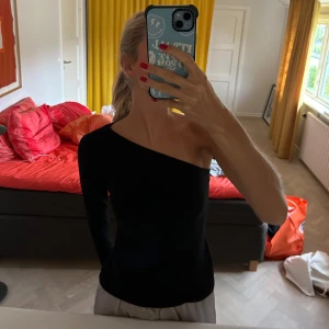 Svart asymmetrisk top  - Svart asymmetrisk topp från Nelly. Använd 1-2 gånger så i nyskick. Strl M