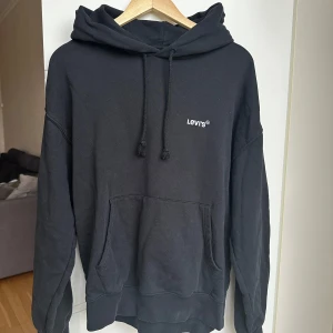 Svart hoodie från Levi's - Säljer en svart hoodie från Levi's med en liten logga på bröstet. Stor och mysig att ha på sig. Andvänd sparsamt, kostar ca 600 nypris☺️