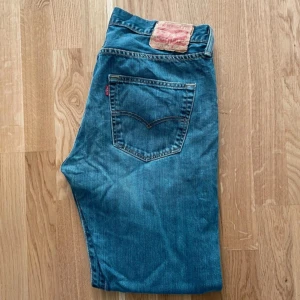 Levis 501 jeans - Klassiska Levis 501 jeans i blå denim. De har en rak passform och är tillverkade i slitstarkt jeans material. En snygg vintage slitning på byxorna som ger dom en unik look. 