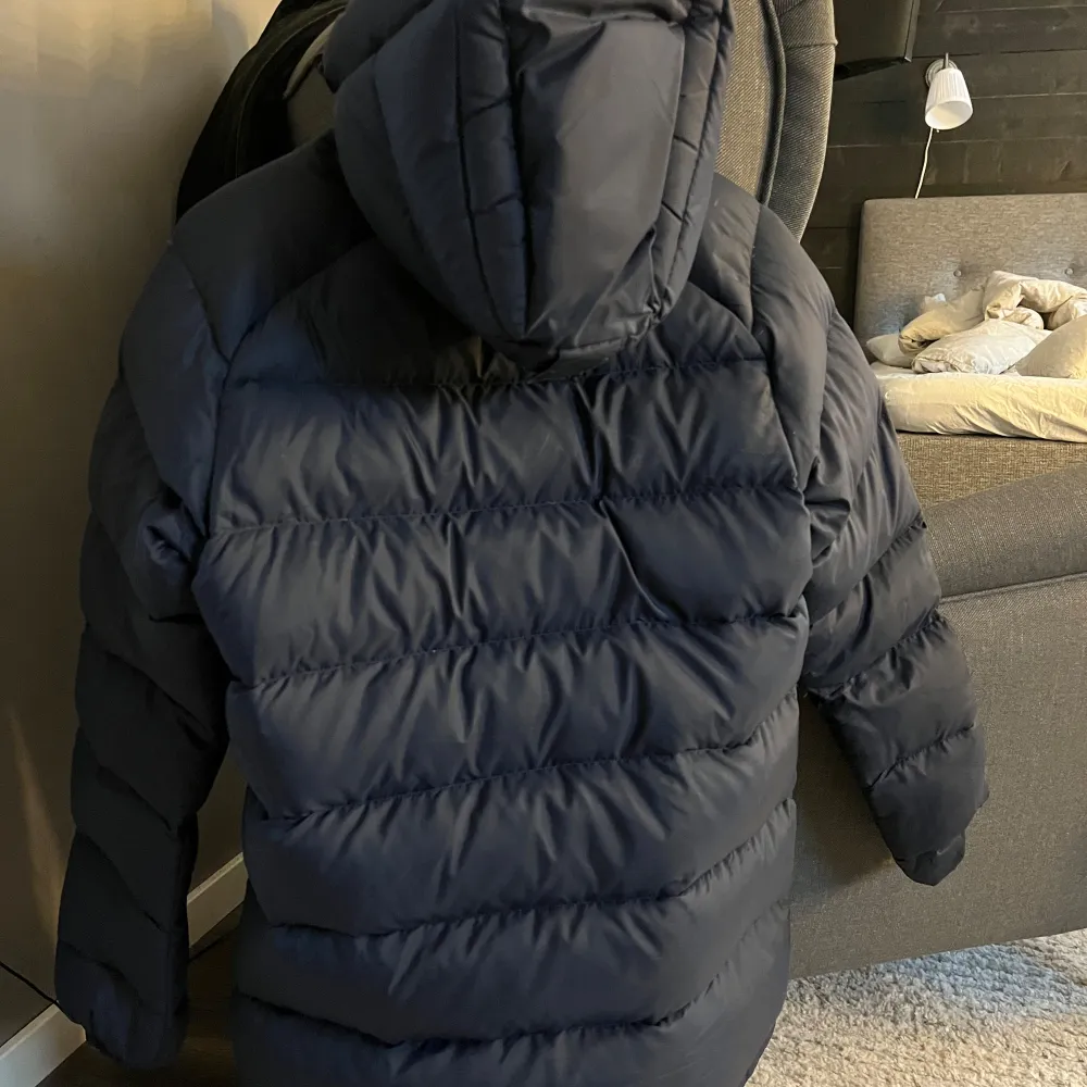 Säljer en marinblå dunjacka från Peak Performance. Jackan har en dragkedja framtill och en justerbar huva. Den är långärmad med elastiska muddar för extra värme. Inköpt i november men säljer den nu då jag letar efter något annat😊Väldigt sparsamt använd och har inga tecken på slitage (ex revor, hål eller fläckar). Inköp för 4200. Takit.