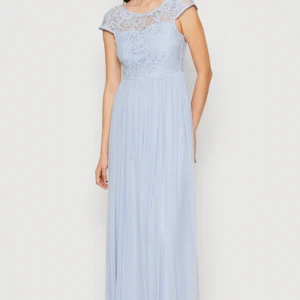 Ljusblå balklänning med spetsdetaljer - Elegant ljusblå långklänning med vackra spetsdetaljer och knappar i ryggen. Klänningen har en rund hals och är ärmlös, vilket ger en stilren look. Perfekt för speciella tillfällen. Endast använd en gång! Nypris runt 900kr! (färgen är mer lik bild 1 i verkligheten, på bild 2,3,4,5 ser klänningen mörkare ut än vad den är) Pris kan diskuteras! Jag kan skicka fler bilder vid intresse!