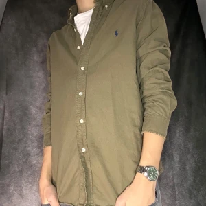 Ralph lauren skjorta - Mycket fint skick. Färg olivgrön, blått märke. Passar perfekt för våren och sommaren, person på bild 180 63 kg. Nypris 1800 mitt 499, medan följare får 50 kr rabbat.