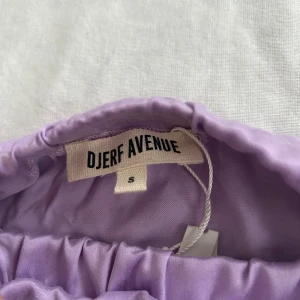 Lila kjol från •Djerf Avenue• - Snygg lila kjol från Djerf Avenue. Kjolen har en liten slits framtill och en elastisk midja för extra komfort. •Djerf Avenue