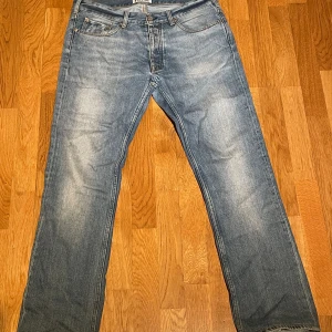 Blå jeans från Acne Studios - Säljer ett par klassiska blå jeans från Acne Studios. De har en straight passform och är tillverkade i denim med en snygg tvätt. Nypris är 3500kr och modellen är 180 cm 70 kg