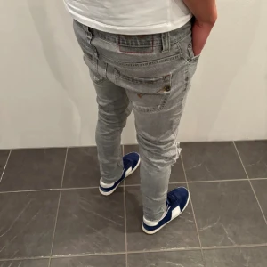 Dondup jeans - Snygga grå jeans från Dondup med slitningar på knäna. De har en tight passform och klassisk femficksdesign. Perfekta för en avslappnad stil med en modern touch. De är ett par väldigt feta jeans perfekta nu till våren! Bara skriva vid minsta fundering!🩶