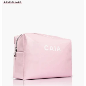 Rosa necessär från CAIA - Snygg rosa necessär från CAIA med dragkedja. Perfekt för att förvara smink eller andra småsaker. Den har en stilren design med märkets logga tryckt i vitt på framsidan. Säljer den då jag har en annan necessär. PRIS GÅR ATT DISKUTERA!