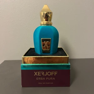 Xerjoff Erba Pura Eau de Parfum - Lyxig parfym från Xerjoff, Erba Pura, i en elegant turkos flaska med gulddetaljer. Även den gamla velvet som ej tillverkas längre! Flaskan rymmer 50 ml och kommer i en stilren förpackning. Perfekt för den som söker en unik och sofistikerad doft. Ungefär 70% kvar. Säg till om ni har några frågor eller om ni vill ha mer bilder!