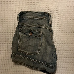 Jeansshorts från Cowest - Snygga jeansshorts från Cowest med en cool tvättad look. De har flera fickor och knappar som detaljer. Perfekta för en avslappnad stil.