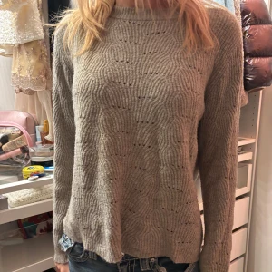 Beige stickad tröja - Säljer en mysig beige stickad tröja med ett diskret vågmönster. Tröjan har långa ärmar och en avslappnad passform, perfekt för kyligare dagar. Passar bra till jeans eller kjol för en avslappnad look.