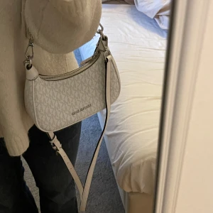 Vit axelväska Michael Kors - Snygg vit axelväska från Michael Kors silverfärgade detaljer. Väskan har en justerbar axelrem och en kedjedetalj. Helt sprillansny köptes i Florens❤️(slutsålda överallt) pris går att diskuteras!