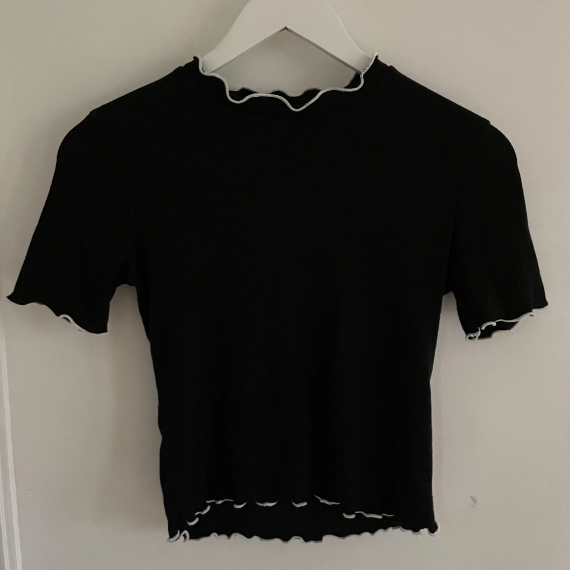 Svart topp med vita räfflor