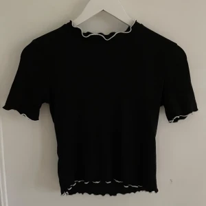 Svart topp med vita räfflor - Svart topp med vita detaljer på kanterna från zara.