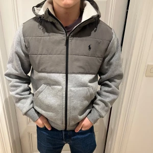 Ralph lauren cardigan  - Grå cardigan från  Polo Ralph Lauren med dragkedja och luva . Jackan har en quiltad överdel och mjukt foder. Cardiganen har används i en månad!