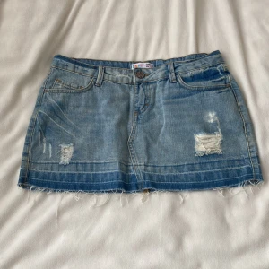 Blå jeanskjol med slitningar - Jättesnygg lågmidjad jeanskjol med coola slitningar 💞 midjemått ca 39 cm, längd ca 29 cm!