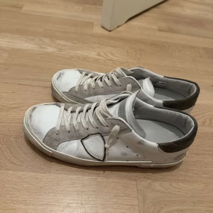 Vita och grå sneakers från Philippe Model - Säljer ett par vita och grå sneakers från Philippe Model i storlek 42. Skorna är i riktigt bra form och ja säljer för att jag helt enkelt inte fått tillräckligt med användning av dom.