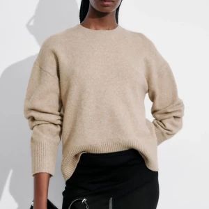 Beige stickad tröja från Other Stories - Säljer en stilren beige stickad tröja från Other Stories. Tröjan har en klassisk rund hals och långa ärmar med ribbade muddar. Perfekt för kyligare dagar och enkel att matcha med olika outfits. Använd ett enstaka gånger, i nyskick