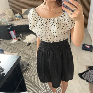 Vit, svart prickig klänning  - Bra skick, fåtal använd och man kan knyta där bak