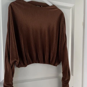 Brun ribbad crop top. Biancas kollektion från Nelly. - Storlek 40, i ny skick men använd några gånger. 