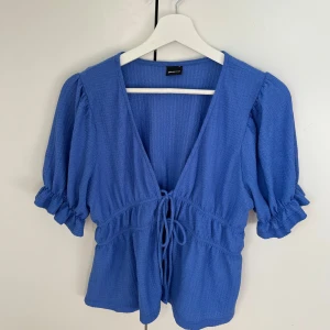 Blå topp med knytning  - Gullig blå topp med knytning fram till