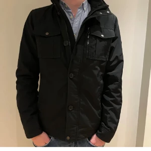 J.lindberg fieldjacka - En asfet J.lindeberg fieldjacka i storlek S/M  Jackan är i väldigt gott skick och är svart  En perfekt jacka för hösten och våren men även lite varmare vinterdagar!