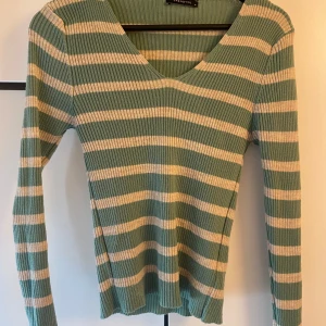Striped green and white long sleeved top - Only worn a few times, true to size although very stretchy , propably works for bigger sizes too.