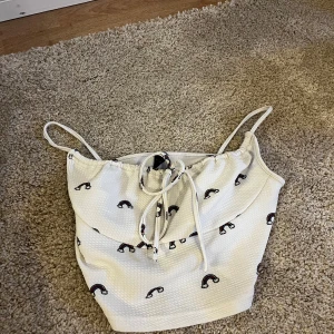 En vit linne topp - Ett vitt linne med regnbågar på från shein 