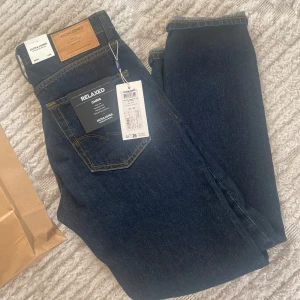 Blå jeans från Jack & Jones - Snygga blå jeans från Jack & Jones i modellen Chris. De har en avslappnad passform med hög midja och relaxed lår, knä och benslut. Perfekta för en casual look.