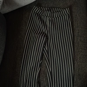 Svart- och vitrandiga byxor - Snygga svart- och vitrandiga byxor med hög midja. Perfekta för en stilren look. Byxorna har en rak passform och är tillverkade i ett bekvämt material.