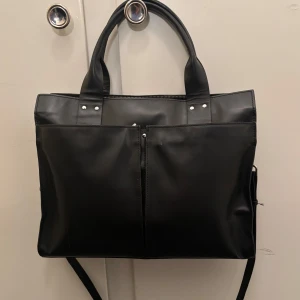 Skinnväska Wera - perfekt datorväska  - Superfin skinnväska från Wera. Perfekt för jobb och dator!  Fint skick förutom några repor i skinnet (se bild) vet inte om det kanske går att få bort med fett eller något. Dustbag ingår.  Sparsamt använd, köpt för ungefär två år sedan. Finns en nästintill identisk på Åhléns för nypris 1999 (verkar vara en uppdaterad modell då den har en liten Wera-logga som denna inte har)