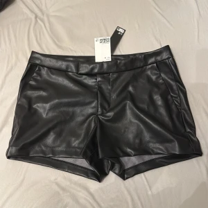 Lågmidjade virala Svarta skinnshorts  - Säljer dessa populära och slutsålda lågmidjade svarta skinnshorts från h&m, helt nya med lappen på, perfekt att ha med långa boots, dom är slutsålda ❤️
