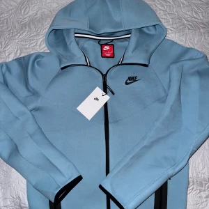 Nike tech fleece - Säljer denna fina blå tröjan som är helt oanvänd, inte ens testad, köpt direkt från Nike och säljer för att jag fick bra erbjudande då jag är medlem. En sån här tröja från Nike helt ny kostar 1499kr. Den är storlek XS men passar S också. Bara höra av sig vid frågor!