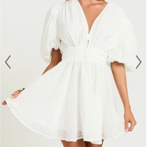 Vit klänning från Showpo - studentklänning  - Jättegullig vit klänning från Showpo med puffiga ärmar och diskret rutmönster. Helt ny med lappen kvar. Passar perfekt som studentklänning eller som sommarklänning🌟🌟