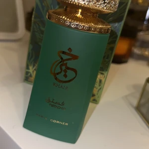 Khair Pistachio Parfym från Paris Corner - Elegant parfymflaska i matt grön med gyllene detaljer och ett dekorativt lock. Doften heter Khair Pista-Chip. Helt ny testad endast en gång 💕