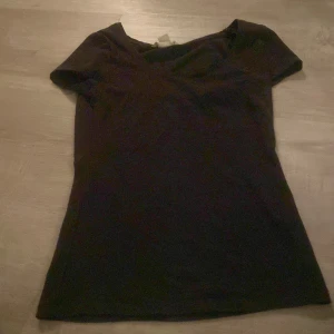 Svart t-shirt - Säljer en enkel svart t-shirt i storlek XS. Perfekt basplagg med korta ärmar och rund hals. Passar till det mesta och är ett måste i garderoben.
