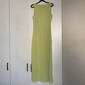 Ljusgrön ärmlös långklänning - Elegant ljusgrön långklänning med ärmlös stil. Perfekt för vardagliga eller festliga tillfällen. Djupare i ryggen. 
