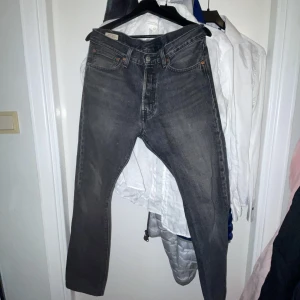 Grå Levis 501 jeans - Säljer ett par klassiska grå Levis 501 jeans. De har en straight passform och är tillverkade i slitstarkt denim. Perfekta för en avslappnad stil.