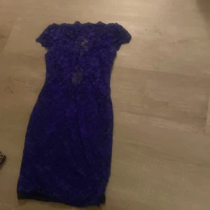 Blå spetsklänning - Elegant blå klänning i spets med korta ärmar. Perfekt för en kväll ute eller en speciell tillställning. Den har en figurnära passform och en vacker spetsdesign som ger en romantisk känsla.