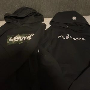 Svarta hoodies från Levi's och Sail Racing -  Superrrrr erbjudande båda för 250 kr eller en för 150 kr!!! Två snygga svarta hoodies, en från Levi's med kamouflagemönster och en från Sail Racing med stilren logga. Perfekta för en casual look.