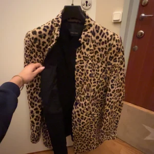 Leopardmönstrad kappa från Zara - Snygg leopardmönstrad kappa från Zara med långa ärmar. Perfekt för att ge din outfit en djärv touch. Kappan har en klassisk passform och är tillverkad i ett mjukt material. Pris kan absolut diskuteras 