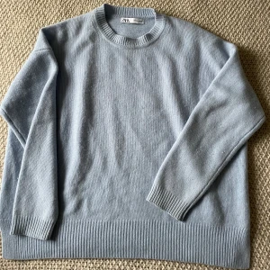 Ljusblå cashmere tröja från Zara - Säljer en stilren ljusblå tröja från Zara. Tröjan har en rund halsringning och långa ärmar med ribbade muddar. Sparsamt använd 