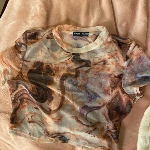 Genomskinnlig festtopp - En färgglad genomskinnlig festtopp🩶Aldrig använd & är i ett ostretchigt material. Den är i storlek M, däremot anser jag att den är en vanlig XS. Säljer också en likadan fast långärmad☝🏼