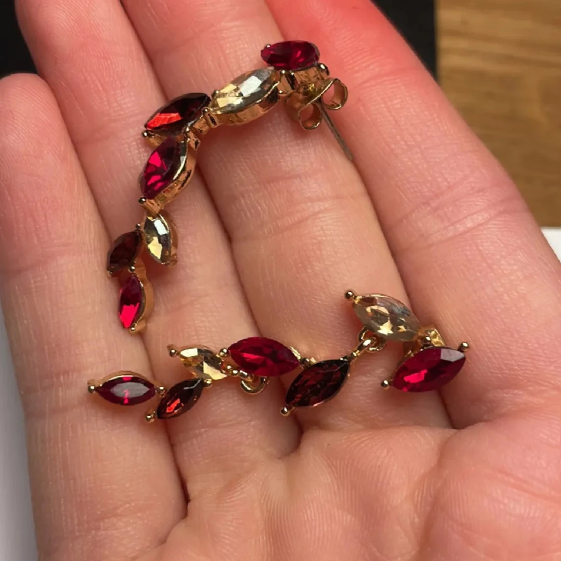 Guldörhängen med röda och klara stenar