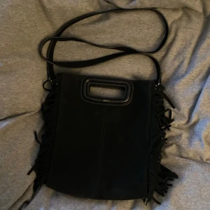 Svart Maje väska!  - Säljer min Maje väska köpt januari 2023 från zalando! Den är använd men inte särskilt sliten mer än att insidan och utsidan är ganska smutsig som går att ta bort med mockarengöring och/eller mockaborste som jag dessvärre inte har! Kan även skicka bevis på köp/äktenhetsbevis!