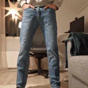 Blå jeans från Weekday - Säljer ett par blå jeans från Weekday i modellen Easy Regular Straight. De har en klassisk femficksdesign och är i mycket bra skick. Perfekta för både vardag och fest! 🕺