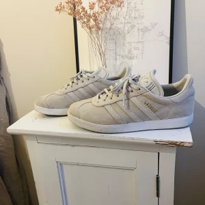 Beige Adidas Gazelle sneakers - Snygga beige Adidas Gazelle sneakers. Köpta på Plick för ungefär ett halvår sen, men var tyvärr för små för mig. Storlek: 38. Använda utomhus en gång hos mig🤍Perfekta för en stilren look!!