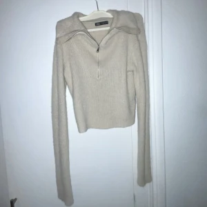 Beige mysig tröja från Zara - Mysig tröja från Zara med dragkedja och hög krage. Tröjan är croppad och har långa ärmar, perfekt för en stilren look. Passar även s 