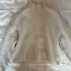 Vit alpaccaull polotröja - Vit stickad polo tröja i alpacca och ull från & other stories. Tröjan har en defekt vid halsen som syns på sista bilden, annars är skicket bra.