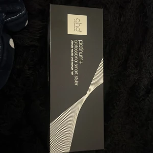ghd Platinum+ Professional Smart Styler - Säljer en ghd Platinum+ Professional Smart Styler. Denna plattång har en elegant svart design och avancerad teknologi för att skydda håret och ge ett perfekt resultat. Perfekt för att skapa både raka och lockiga frisyrer.